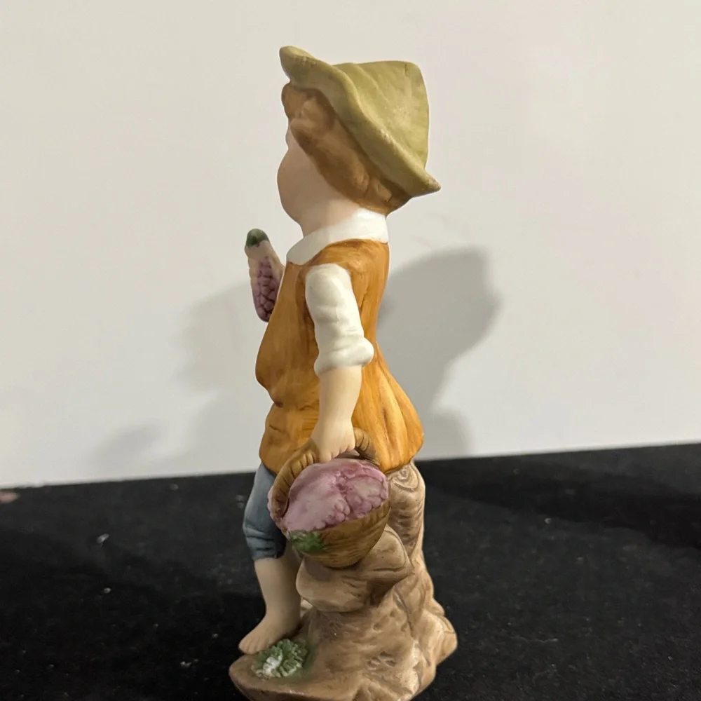 vintage hand-painted porcelain figurines of a boy and girl carrying baskets.